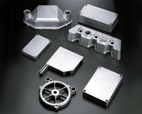 The image shows a group of aluminum parts on a black surface, which appear to be die-cast aluminum parts. The parts are arranged in a neat and orderly fashion, with some of them overlapping each other